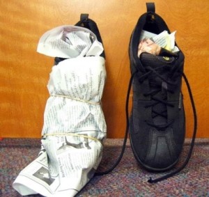 Với giày bị dính nước hãy nhét và quấn giấy bao quanh để giấy hút nước được nhanh chóng.